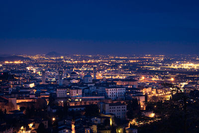 High angle view of illuminated buildings in city at night, bergamo 