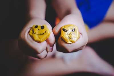 Close-up of person holding yellow eggs