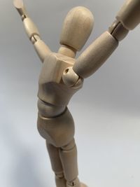 Close-up of figurine on table against white background