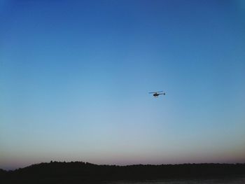 Helicopter flying over volga river against clear sky