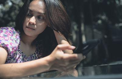 Young woman with moody face when her check a mobile phone