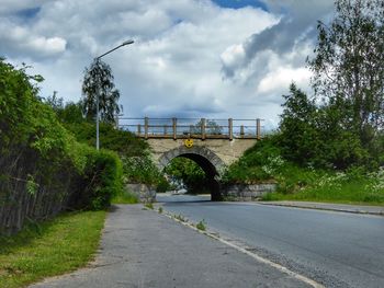 Bridge over street in city against sky