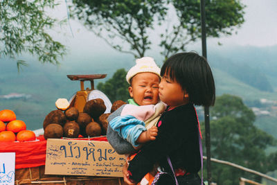 Side view of mother and daughter standing outdoors