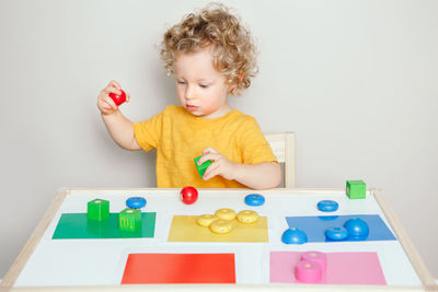 Cute boy playing with toy on table