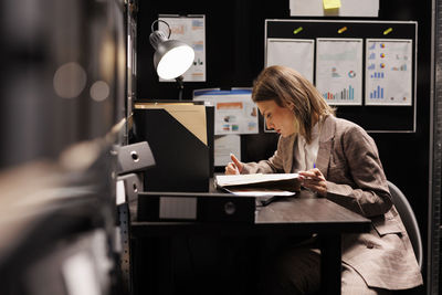 Midsection of woman using laptop at office