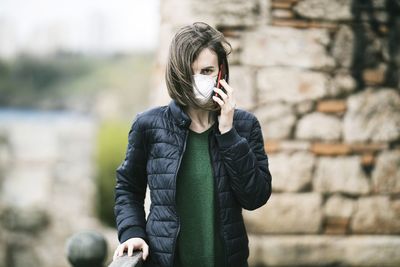 Full length of woman standing against wall