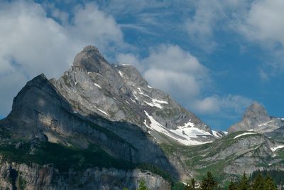 Low angle view of snowcapped mountains against sky