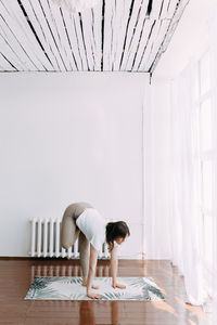 Woman standing on table at home