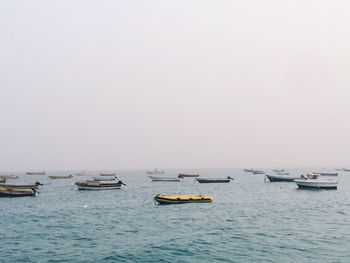 Boats in sea against clear sky