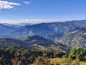 Scenic view of mountains against blue sky