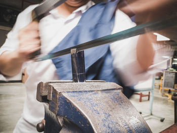 Close-up of man working on metal