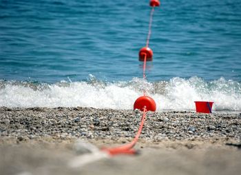 Close-up of red buoys on beach