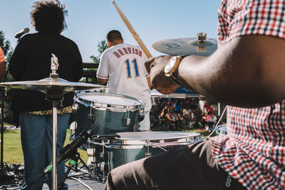 Rear view of man playing music concert against sky