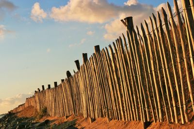 Low angle view of wooden fence against sky on sunny day