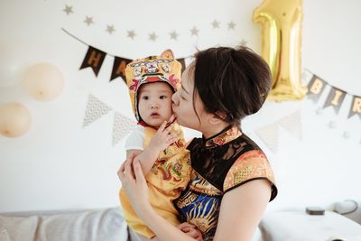 Portrait of a mom kissing her baby