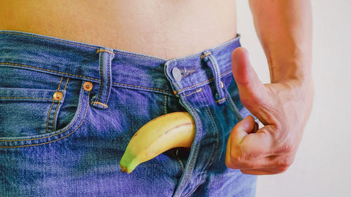 Close-up of banana in man jeans pant