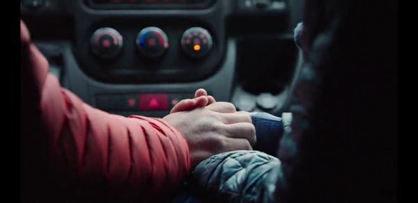 Couple holding hands in car