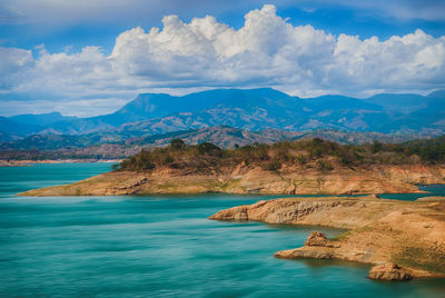 Scenic view of sea and mountains against sky