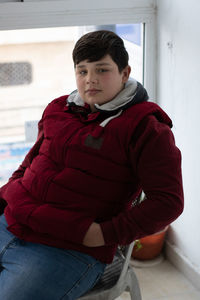 Portrait of young man sitting in snow