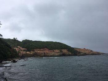 Scenic view of sea and mountains against sky