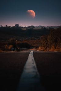 Surface level of road against sky during sunset