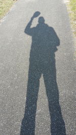 Shadow of man photographing on road