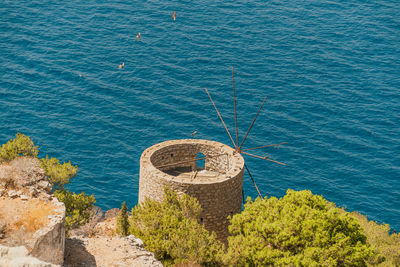 High angle view of an old stone windmill by the sea on hydra island in greece.