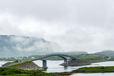 Bridge over mountain against sky