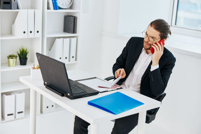 Man using laptop while sitting on table