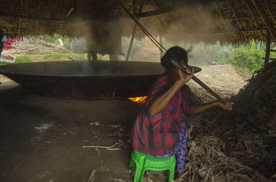 Woman preparing food in hut
