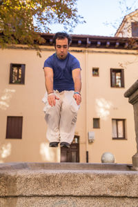 Full length of man jumping in artificial pond