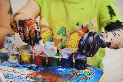 Midsection of person holding multi colored painting