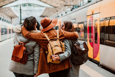 Happy friends standing on station