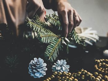 Cropped hands arranging christmas decorations on table