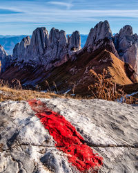 Scenic view of rocky mountains against sky and trail markings