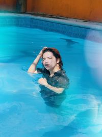 Portrait of smiling woman swimming in pool