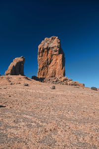 Rock formations on landscape against clear blue sky