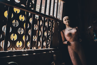 Portrait of young man standing against railing