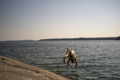 Boy jumping into water