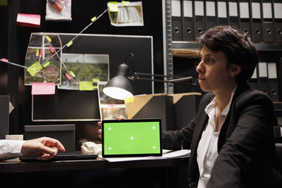 Young woman using laptop while sitting on table