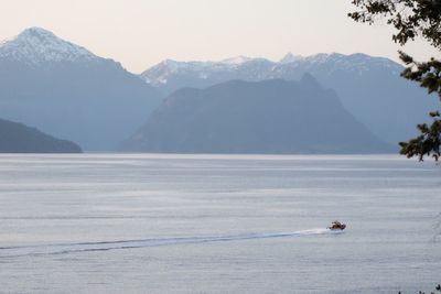 Scenic view of sea and mountains against sky