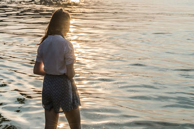 Rear view of woman standing in water