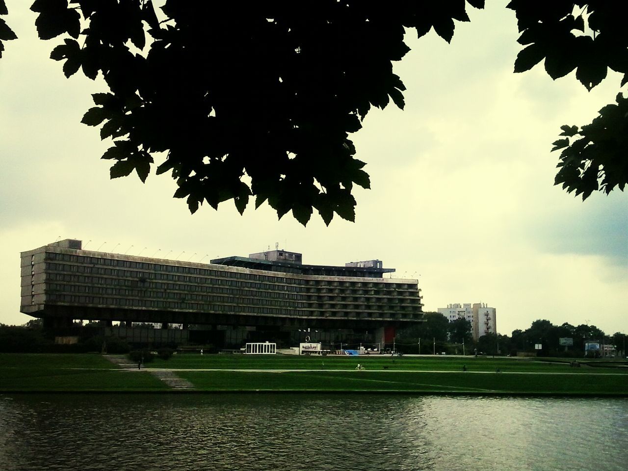 architecture, building exterior, built structure, sky, tree, water, city, waterfront, cloud - sky, river, cloud, residential building, building, growth, modern, reflection, outdoors, cloudy, day, office building