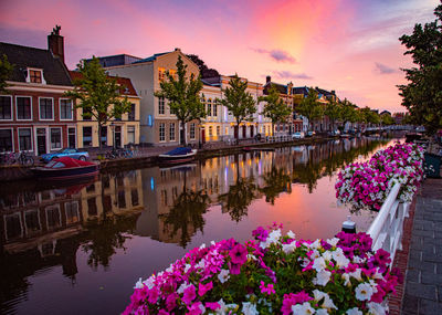 Canal amidst buildings against sky during sunset