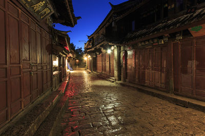 Illuminated alley amidst traditional houses at dusk