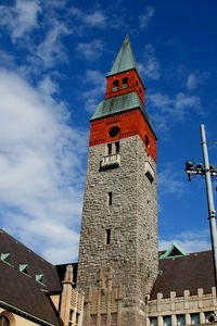 Low angle view of clock tower against cloudy sky