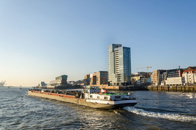 Scenic view of sea and buildings against clear sky