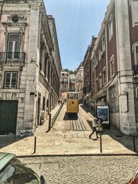 Street amidst buildings in town against sky