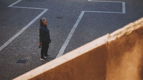 High angle view of woman standing on road