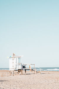 Lifeguard hut on beach against clear sky